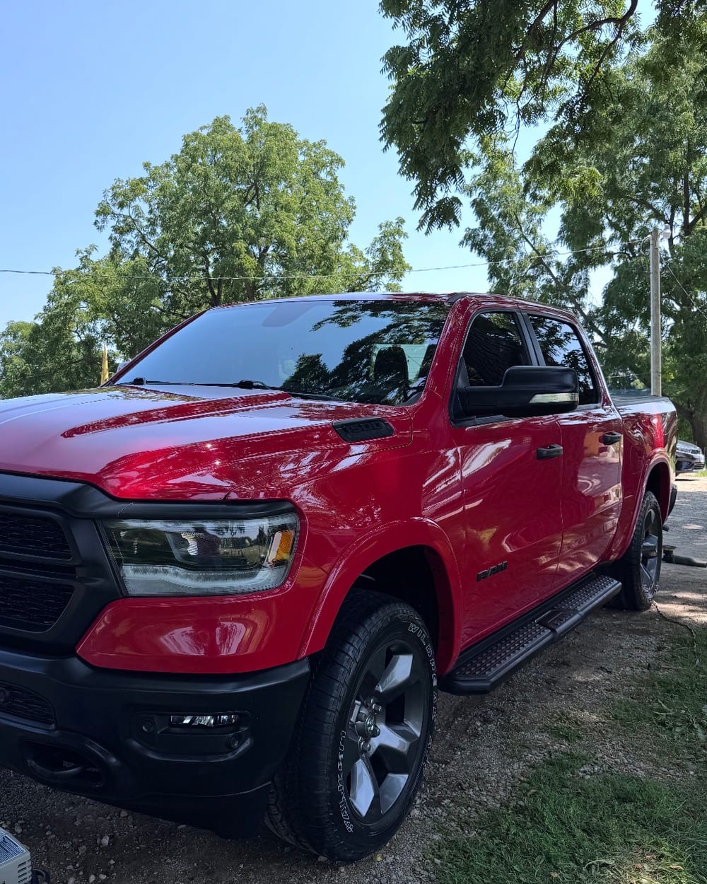 The same red pickup truck after a full exterior detail, paint glossy and clean
