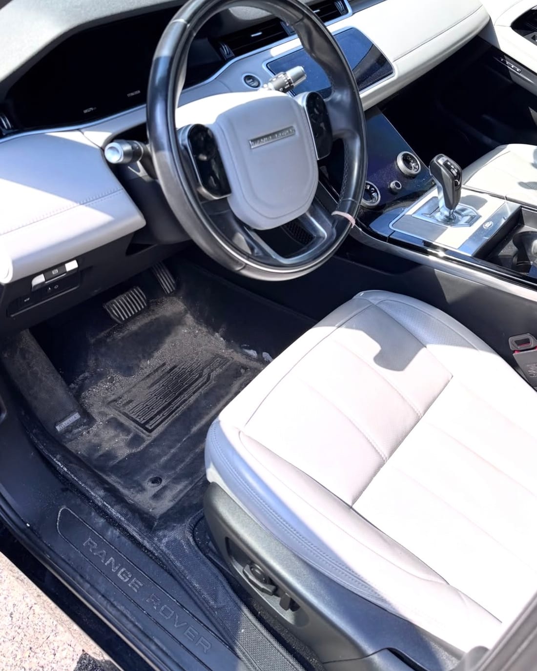 A car cabin before detailing, floor mats and door sill covered in dust
